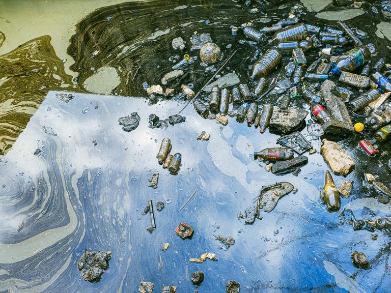 Starke Wasserverschmutzung in einem Stadthafen in Izmir, Konak, Türkei, sichtbar: Treibende Plastikflaschen, Müll und ein giftiger Ölteppich treiben auf der Wasseroberfläche. Starke Wasserverschmutzung in einem Stadthafen in Izmir, Konak, Türkei, sichtbar: Treibende Plastikflaschen, Müll und ein giftiger Ölteppich treiben auf der Wasseroberfläche.