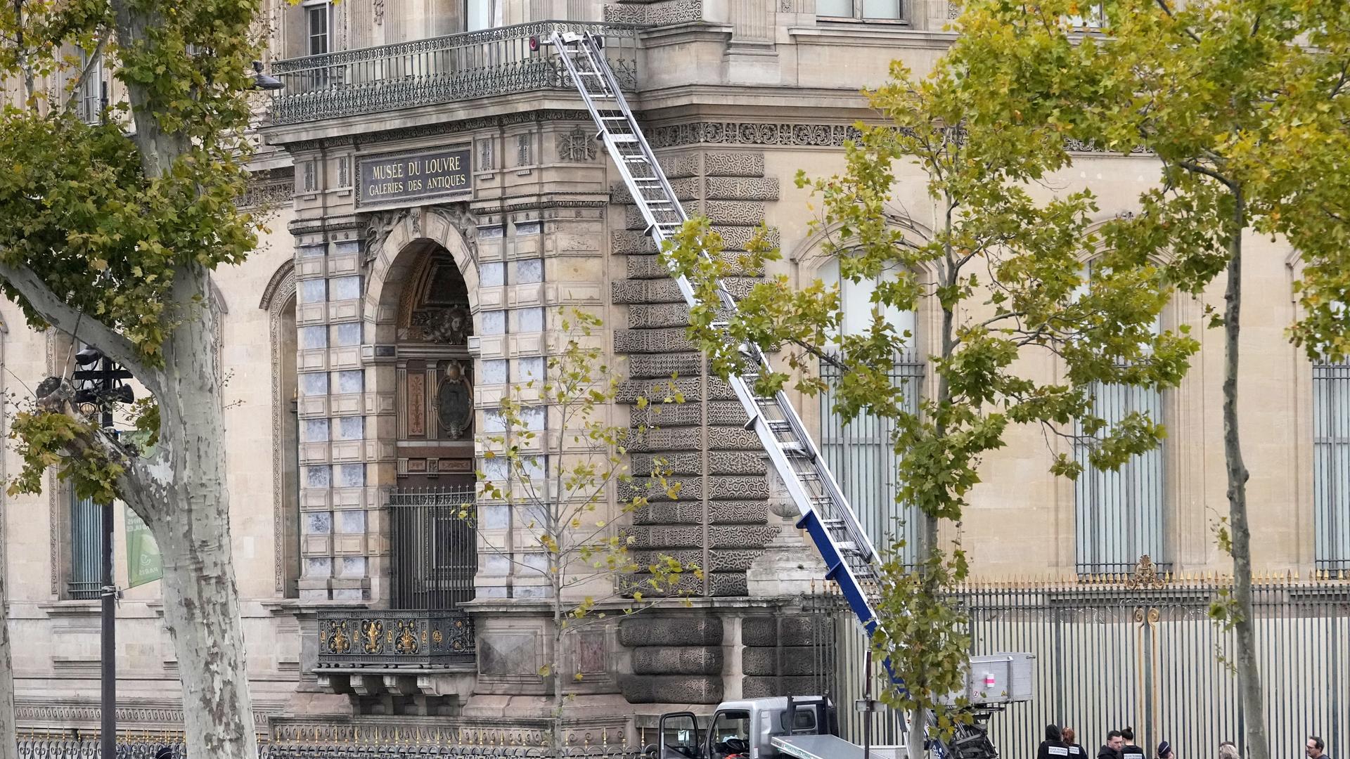 Polizisten neben einem Lastenaufzug-Fahrzeug, mit dem Diebe ins Louvre eingestiegen sind. Polizisten neben einem Lastenaufzug-Fahrzeug, mit dem Diebe ins Louvre eingestiegen sind.