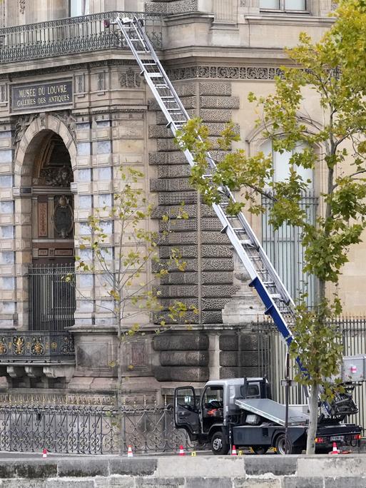 19.10.2025, Paris: Polizisten neben einem Lastenaufzug-Fahrzeug, mit dem Diebe ins Louvre eingestiegen sind.