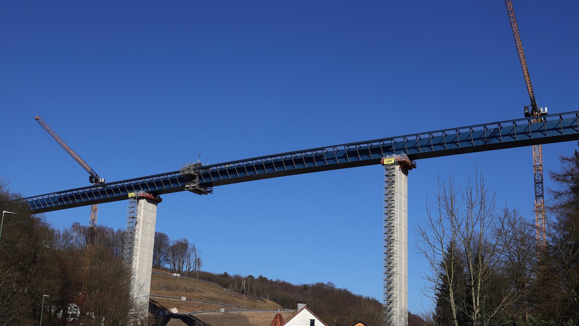Die neue Rahmede-Tal-Brücke aus der Entferrnung. Daneben stehen Kräne.