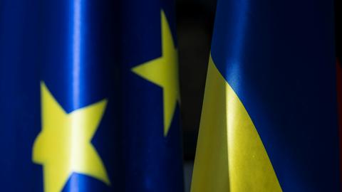 Zwei Fahnen der Europäischen Union und der Ukraine nebeneinander. Beide mit den Farben blau und gelb.