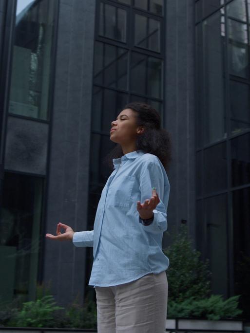 Im stressigen Alltag sucht eine Frau durch Meditation Entspannung