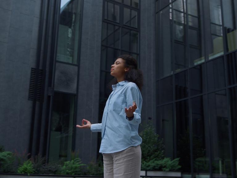 Im stressigen Alltag sucht eine Frau durch Meditation Entspannung