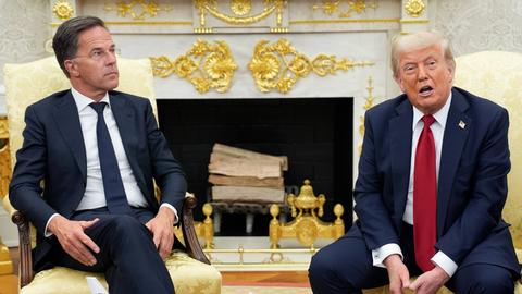 Donald Trump und Mark Rutte sitzen auf zwei Stühlen nebeneinander. Im Hintergrund ist ein Kamin zu sehen.