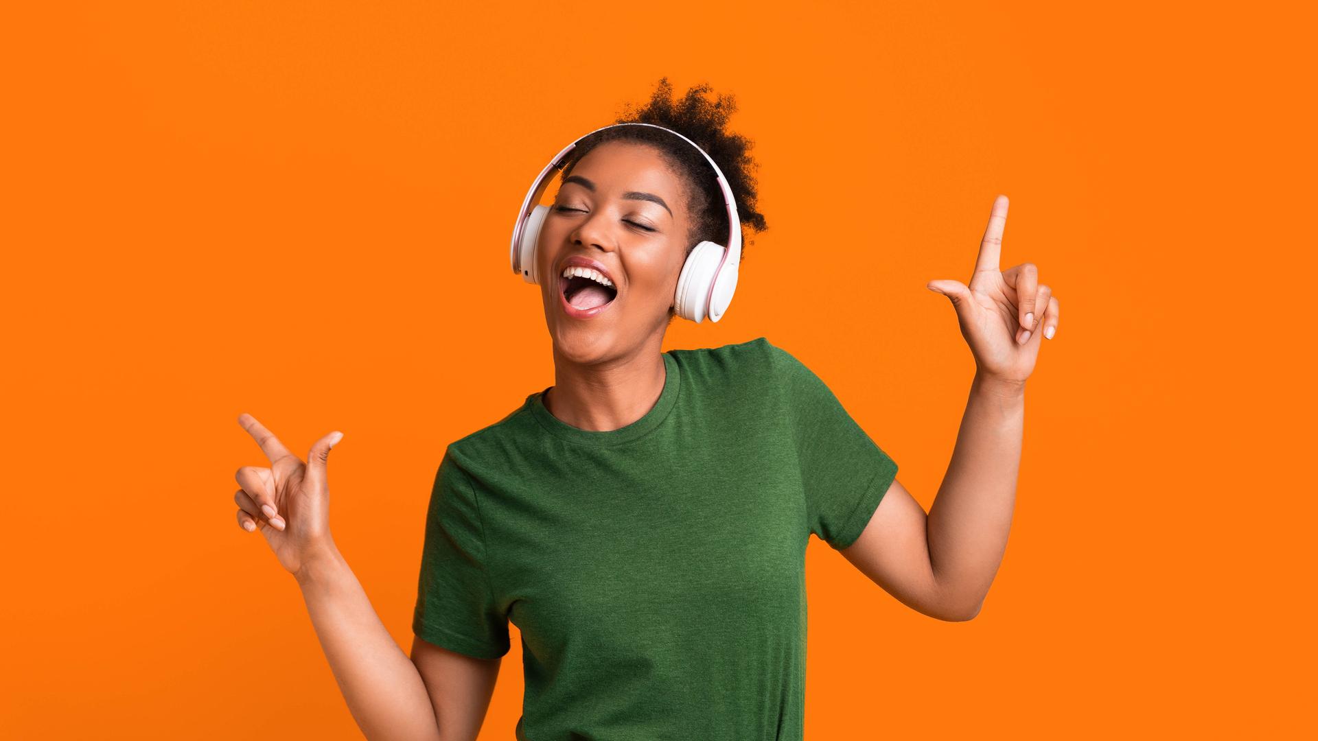 Eine Frau, die Kopfhörer aufgesetzt hat, bewegt sich zu Musik