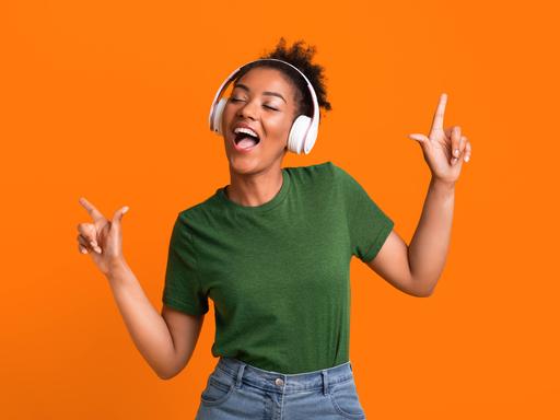 Eine Frau, die Kopfhörer aufgesetzt hat, bewegt sich zu Musik