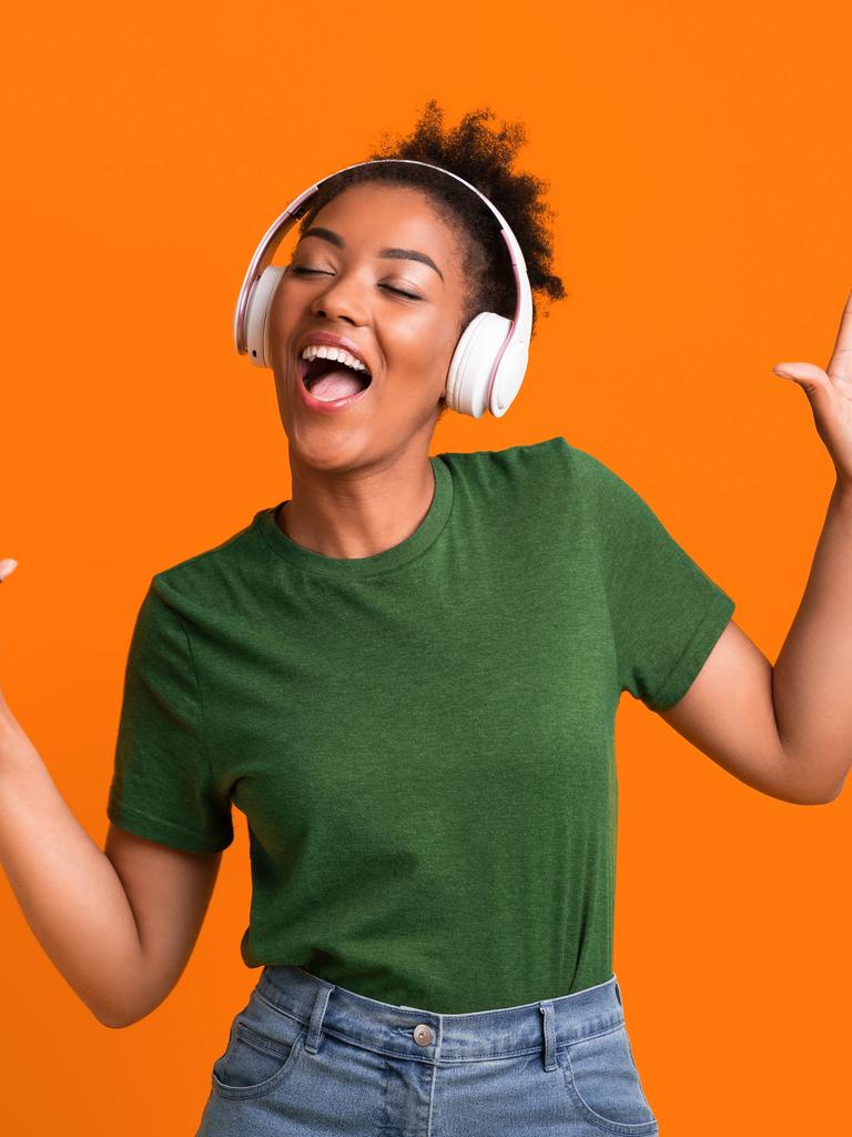 Eine Frau, die Kopfhörer aufgesetzt hat, bewegt sich zu Musik