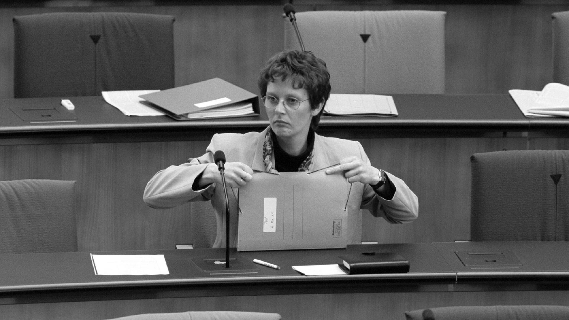 Frauenministerin Claudia Nolte sitzt 1997 alleine auf der Regierungsbank im Bonner Bundestag, in ihrer Hand Akten