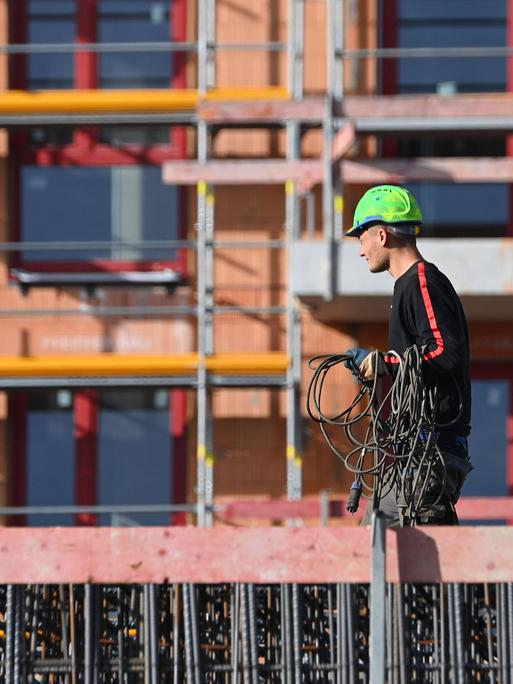 Bauarbeiter auf einer Großbaustelle eines Mehrfamilienhauses