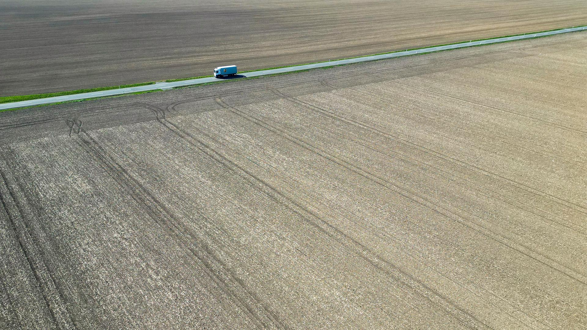 Ein Lkw fährt zwischen trockenen Feldern über eine Landstraße in Nordsachsen. Auch in den kommenden Tagen sagen die Meteorologen keine Niederschläge voraus. (Luftaufnahme mit Drohne)