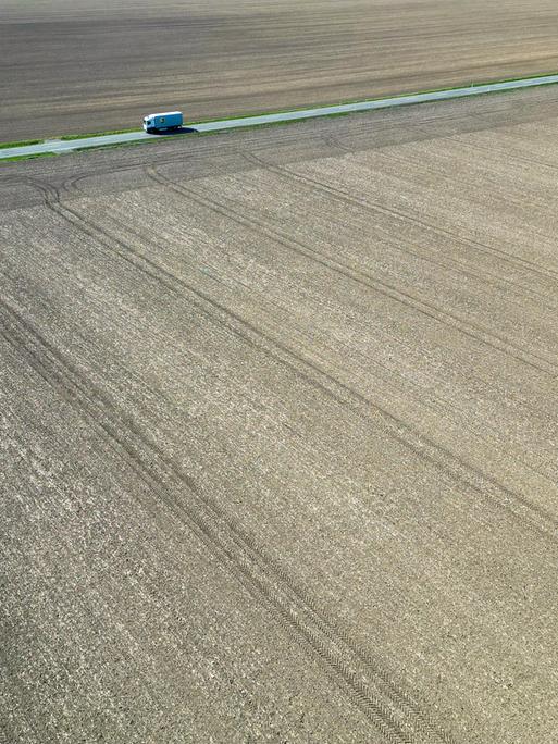 Ein Lkw fährt zwischen trockenen Feldern über eine Landstraße in Nordsachsen. Auch in den kommenden Tagen sagen die Meteorologen keine Niederschläge voraus. (Luftaufnahme mit Drohne)