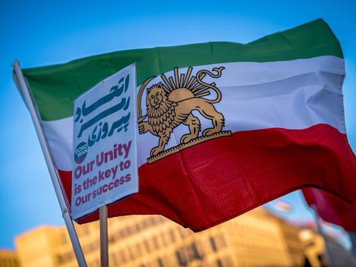 Bei einer Demonstration gegen das iranische Regime im Januar 2026 in Berlin halten Protestierende die iranische Flagge mit einem Löwen in der Mitte hoch. Sie gilt als Zeichen des Widerstands gegen die Islamische Republik.