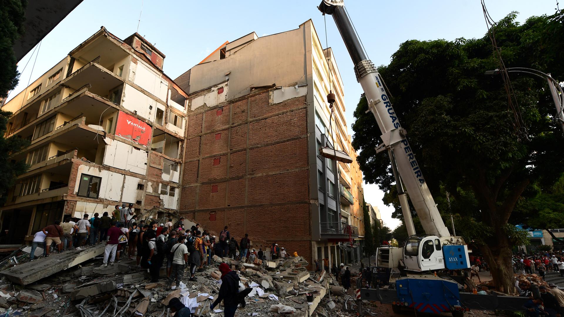 Rettungskräfte und Einheimische setzen einen Kran ein, um nach einem Erdbeben am 10. August 2026 in Pereira, Kolumbien, Trümmer zu beseitigen und an einem eingestürzten Gebäude nach Überlebenden zu suchen.