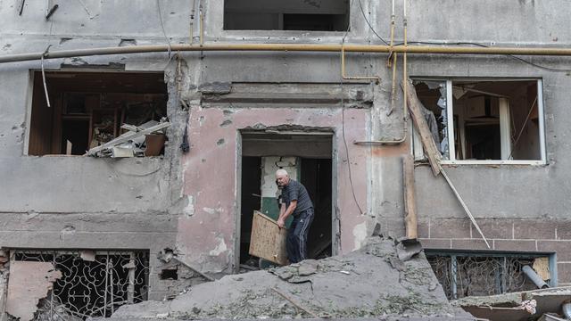 Ein Mann in der Ukraine räumt Kriegs-Trümmer weg