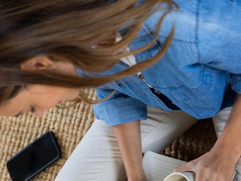 Journaling - eine junge Frau schreibt in ein leeres Notizbuch. Journaling - eine junge Frau schreibt in ein leeres Notizbuch.