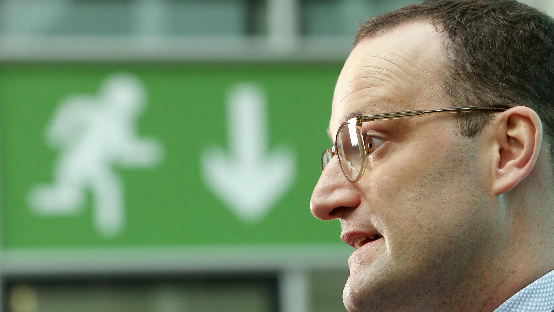31.10.2018, Berlin: Jens Spahn (CDU), damals Bundesgesundheitsminister, vor einem grünen Schild im Atrium des Bundesgesundheitsministeriums, das mit einem Pfeil zum Ausgang weist 31.10.2018, Berlin: Jens Spahn (CDU), damals Bundesgesundheitsminister, vor einem grünen Schild im Atrium des Bundesgesundheitsministeriums, das mit einem Pfeil zum Ausgang weist