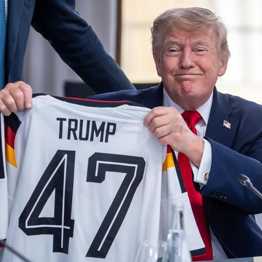 US-Präsident Donald Trump hält ein DFB-Fußball-Trikot mit dem Namen Trump und der Rückennummer 47, das er vom deutschen Kanzler Friedrich Merz bei einem Treffen der G7 bekommen hat 