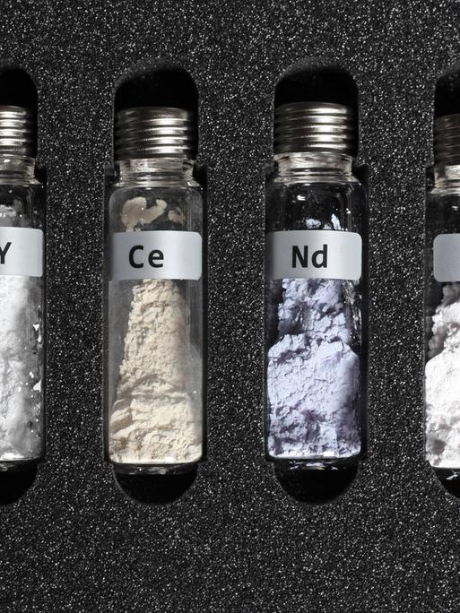 Seltene Erden in kleinen Glasbehältern, die in einem schützenden Schaumstoff eingepasst sind Seltene Erden in kleinen Glasbehältern, die in einem schützenden Schaumstoff eingepasst sind