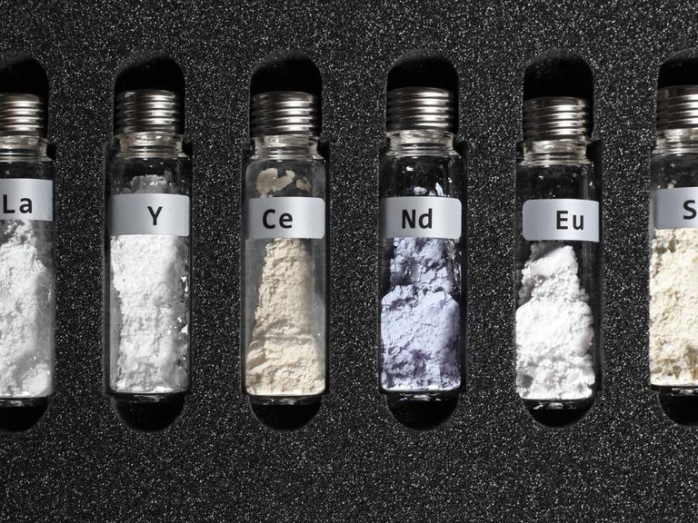 Seltene Erden in kleinen Glasbehältern, die in einem schützenden Schaumstoff eingepasst sind Seltene Erden in kleinen Glasbehältern, die in einem schützenden Schaumstoff eingepasst sind