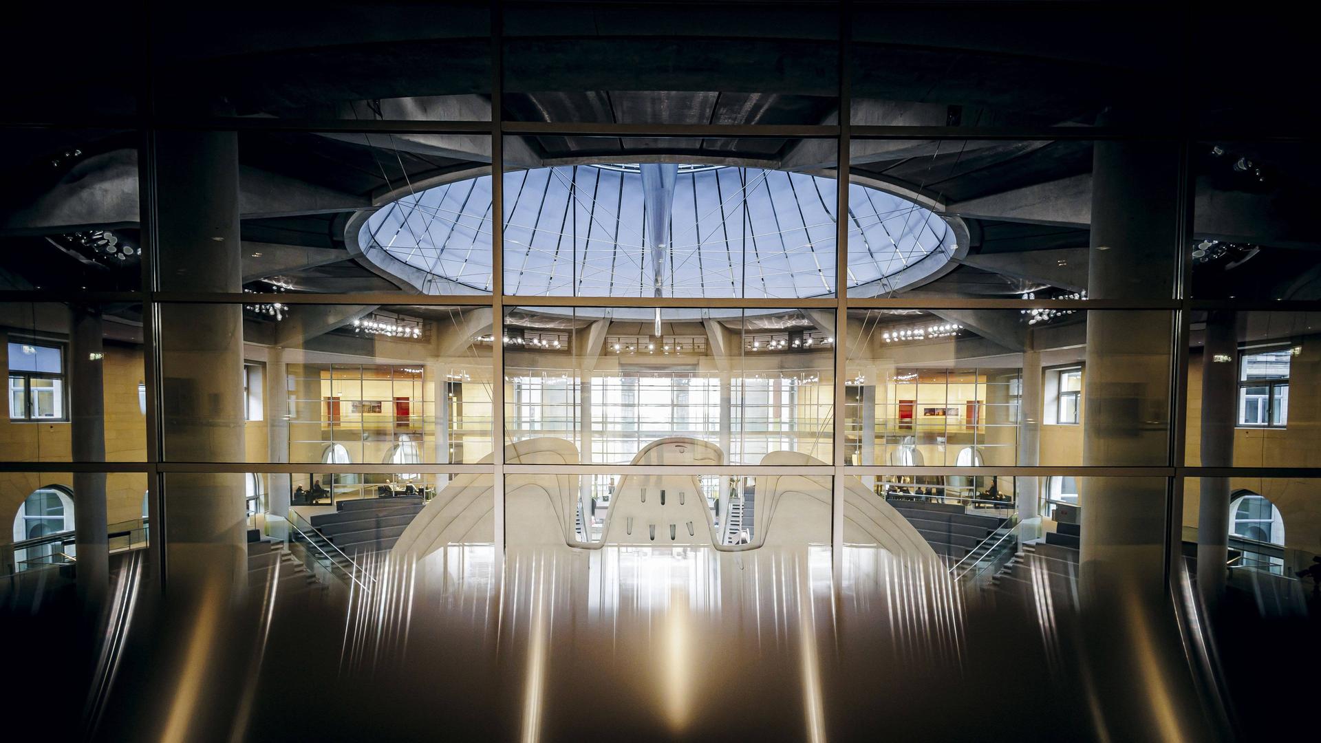 Blick durch eine Glasfront von hinten auf den Bundesadler im Plenum des Bundestages. Blick durch eine Glasfront von hinten auf den Bundesadler im Plenum des Bundestages.