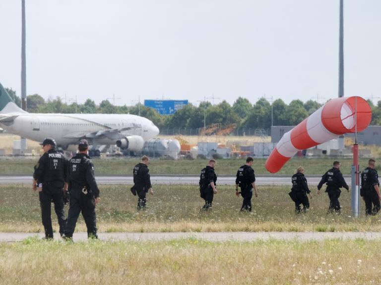 Polizisten gehen über eine Wiese auf dem Gelände des Flughafen Leipzig/Halle (7.08.2026) Polizisten gehen über eine Wiese auf dem Gelände des Flughafen Leipzig/Halle (7.08.2026)