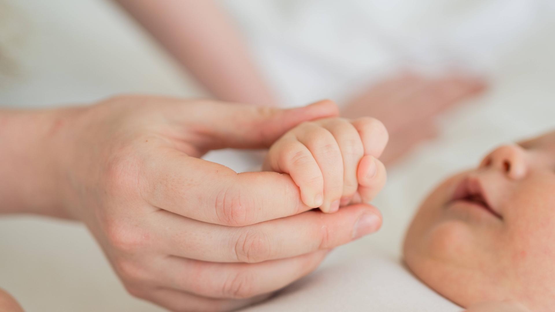 Eine Mutter hält die Hand ihres Babys Eine Mutter hält die Hand ihres Babys