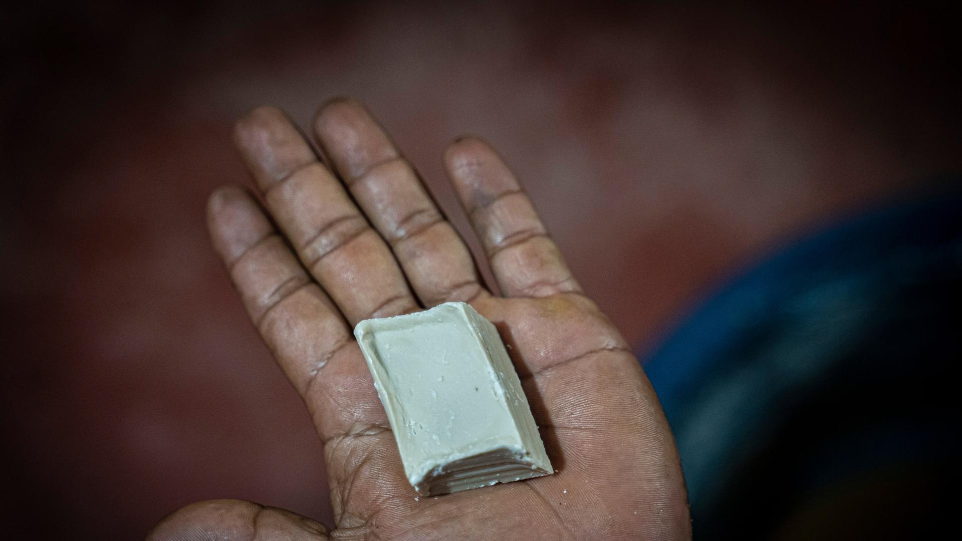 Ein Mann zeigt ein Stück Kokapaste am Rande einer Koka-Plantage, wo Kokablätter zu Paste verarbeitet werden.