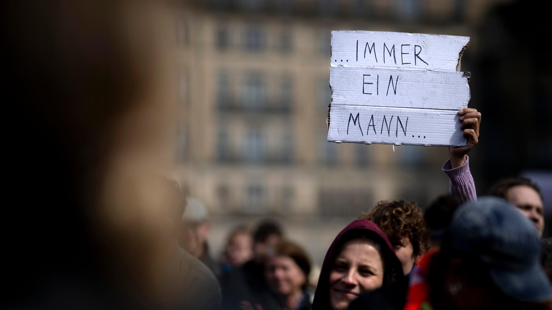 Person bei einer Demonstration gegen sexualisierte Gewalt an Frauen hält ein Schild hoch, auf dem "Immer ein Mann" steht Person bei einer Demonstration gegen sexualisierte Gewalt an Frauen hält ein Schild hoch, auf dem "Immer ein Mann" steht