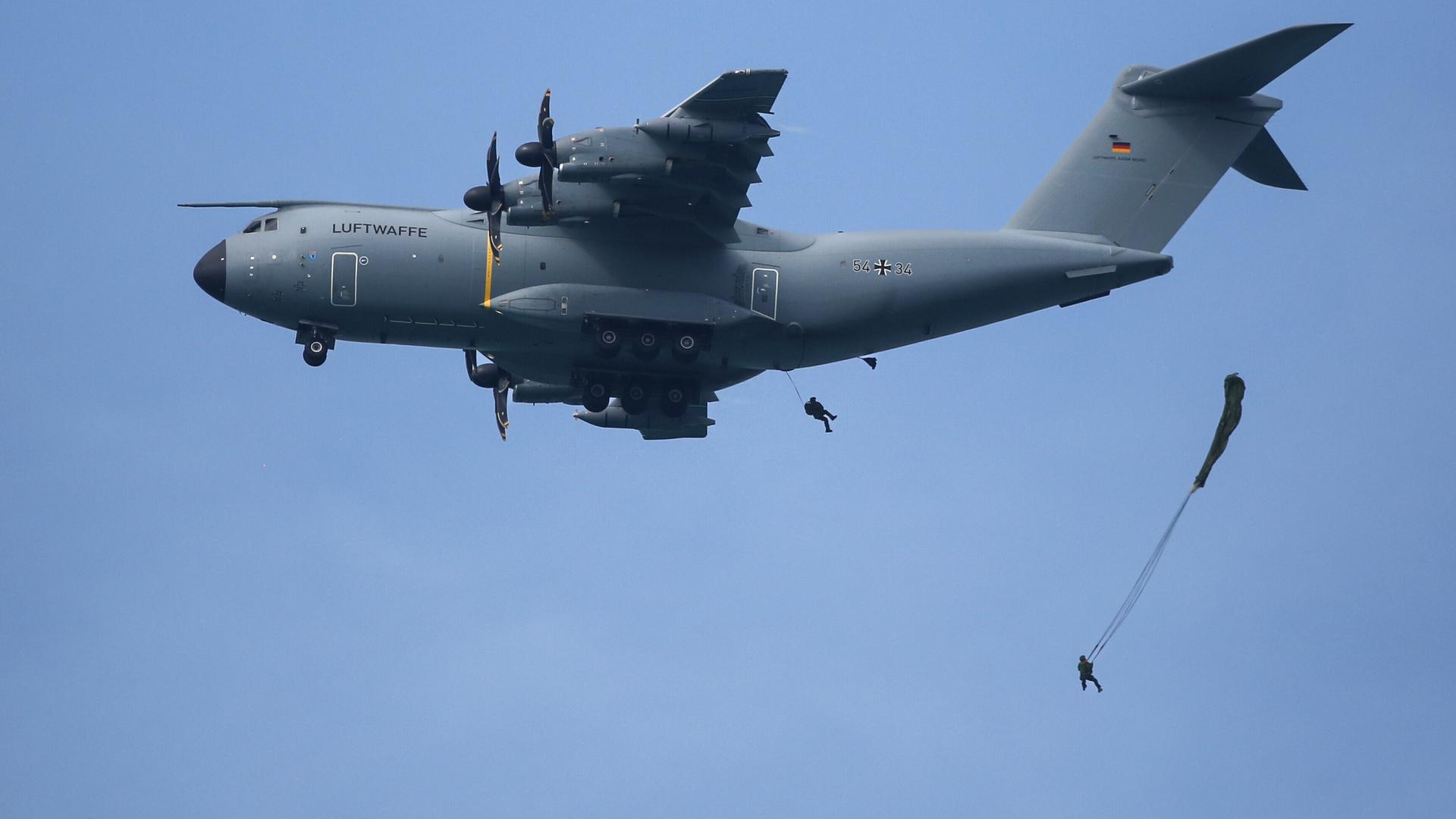 Soldaten des Fallschirmjägerregiments 26 aus Zweibrücken springen im Rahmen einer Übung mit einem Fallschirm aus einem Airbus A400M.