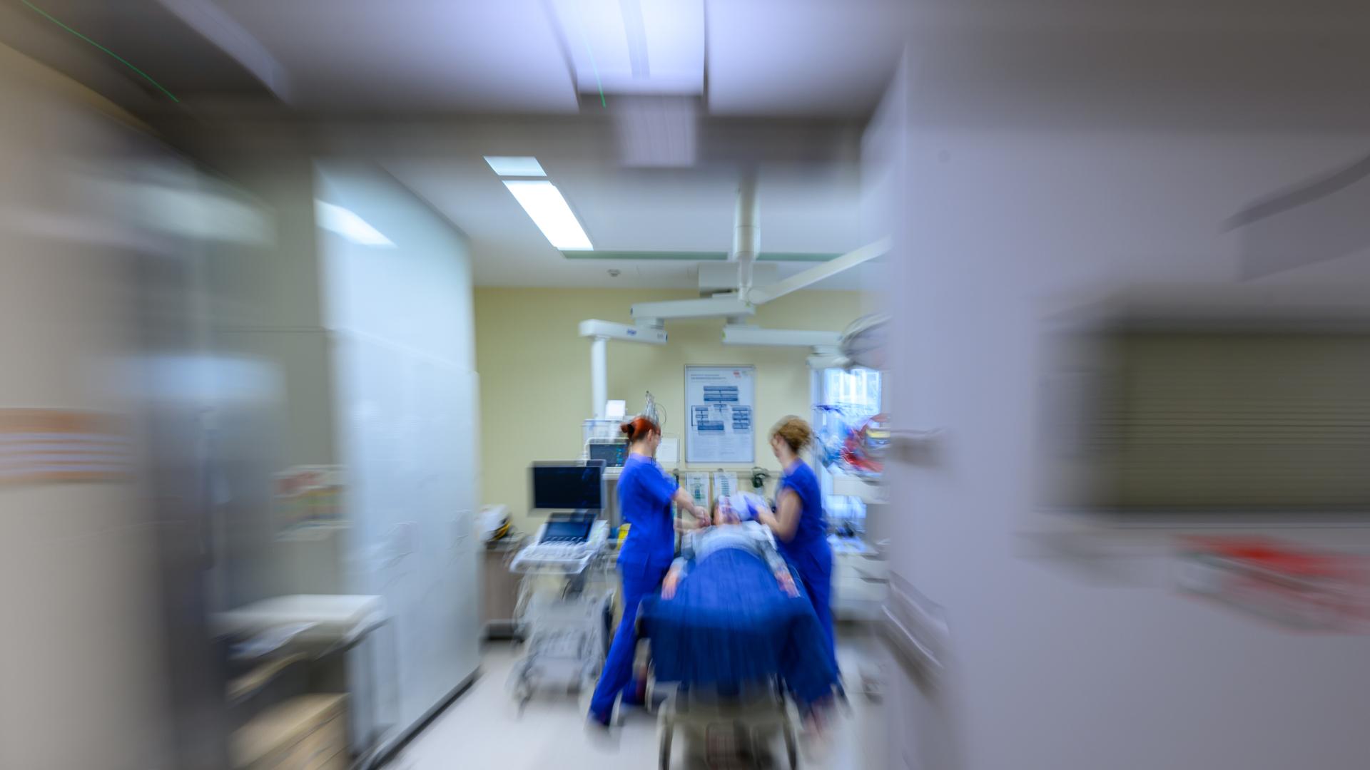 Medizinisches Personal behandelt eine liegende Person im Schockraum (Aufnahme mit Zoomeffekt) Medizinisches Personal behandelt eine liegende Person im Schockraum (Aufnahme mit Zoomeffekt)