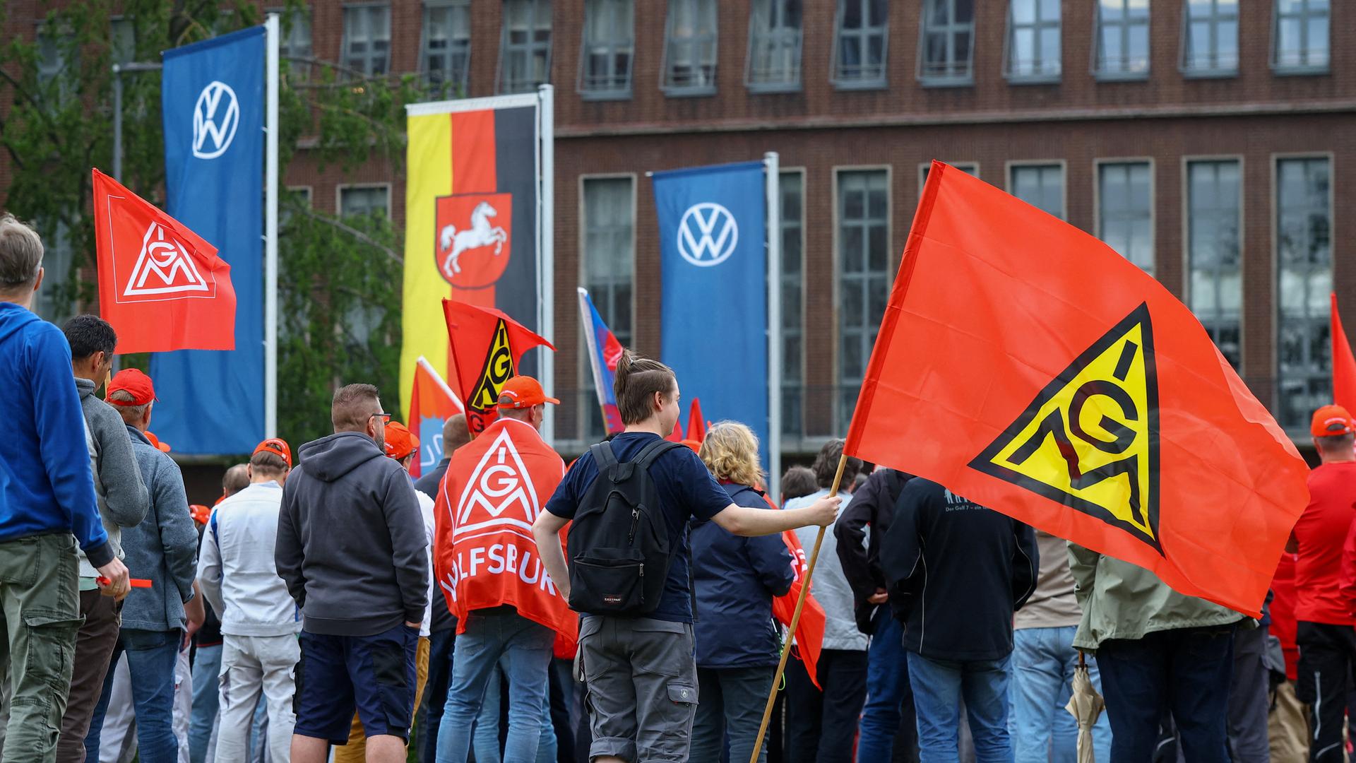 Mitarbeiter von Volkswagen stehen mit Fahnen der Gewerkschaft IG Metall bei einer Kundgebung gegen Umstrukturierungen und Pläne für massiven Stellenabbau am VW-Stammsitz im Volkswagenwerk Wolfsburg (9.07.2026) Mitarbeiter von Volkswagen stehen mit Fahnen der Gewerkschaft IG Metall bei einer Kundgebung gegen Umstrukturierungen und Pläne für massiven Stellenabbau am VW-Stammsitz im Volkswagenwerk Wolfsburg (9.07.2026)