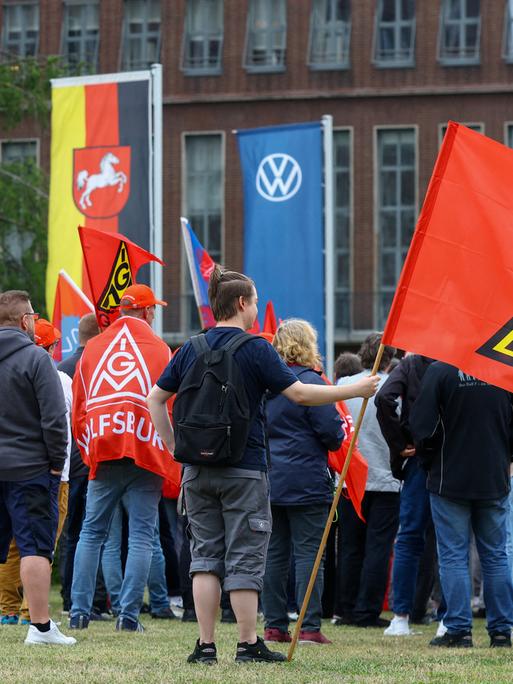 Mitarbeiter von Volkswagen stehen mit Fahnen der Gewerkschaft IG Metall bei einer Kundgebung gegen Umstrukturierungen und Pläne für massiven Stellenabbau am VW-Stammsitz im Volkswagenwerk Wolfsburg (9.07.2026) Mitarbeiter von Volkswagen stehen mit Fahnen der Gewerkschaft IG Metall bei einer Kundgebung gegen Umstrukturierungen und Pläne für massiven Stellenabbau am VW-Stammsitz im Volkswagenwerk Wolfsburg (9.07.2026)