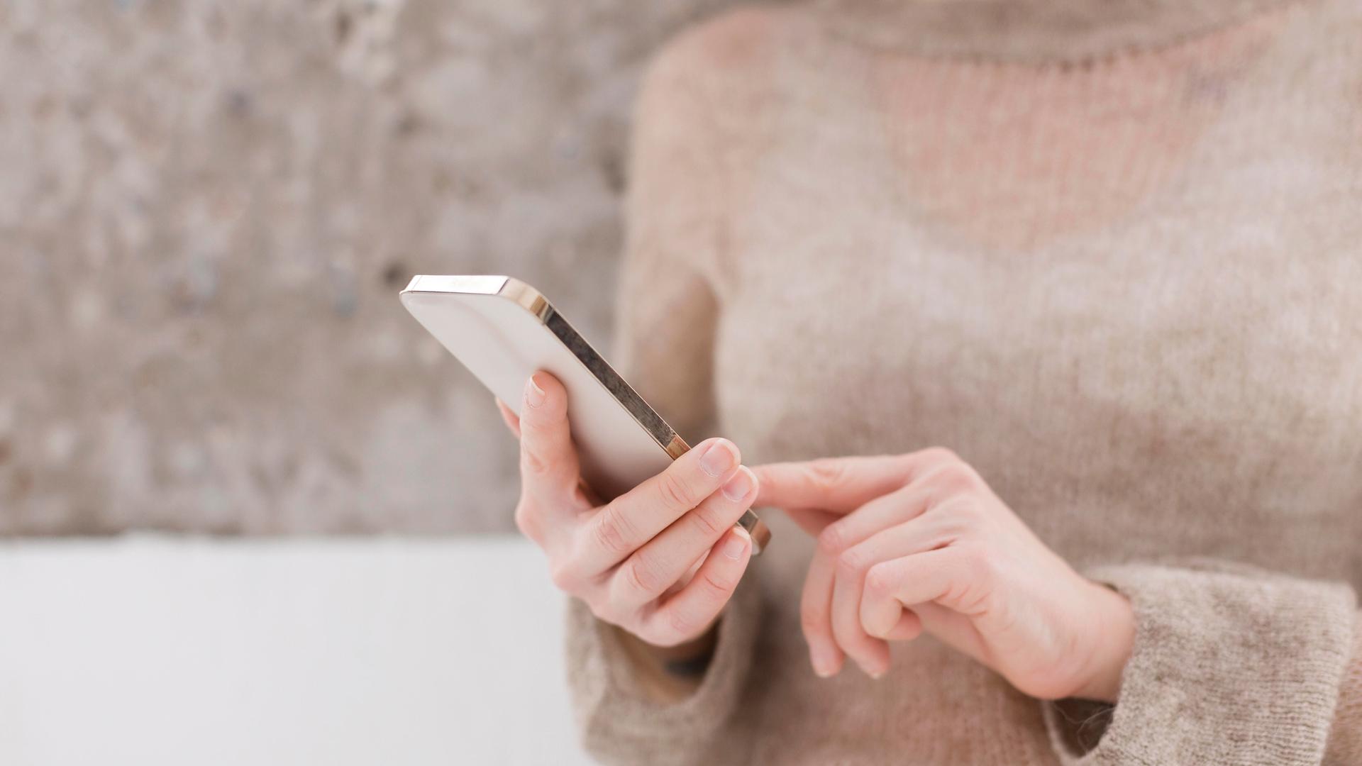 Frau hebt Zeigefinger, um auf Smartphone zu tippen Frau hebt Zeigefinger, um auf Smartphone zu tippen