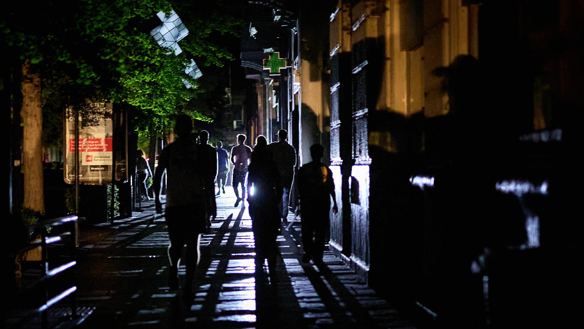 Menschen gehen mit Taschenlampen durch die Stadt
