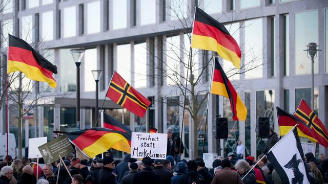 Demonstranten mit Plakat Freiheit statt Merkelismus und Fahnen in Schwarz-Rot-Gold auf einer Demonstration von Baergida bzw. Bergida, einer Form von Pegida, am 06.02.2016 am Hauptbahnhof im Regierungsviertel in Berlin