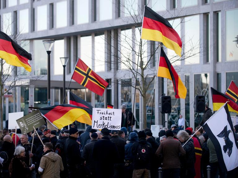 Demonstranten mit Plakat Freiheit statt Merkelismus und Fahnen in Schwarz-Rot-Gold auf einer Demonstration von Baergida bzw. Bergida, einer Form von Pegida, am 06.02.2016 am Hauptbahnhof im Regierungsviertel in Berlin
