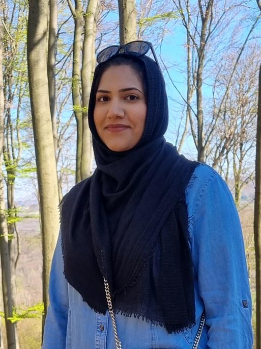 Humaira Waseem blickt in die Kamera, sie steht in einem Wald.
