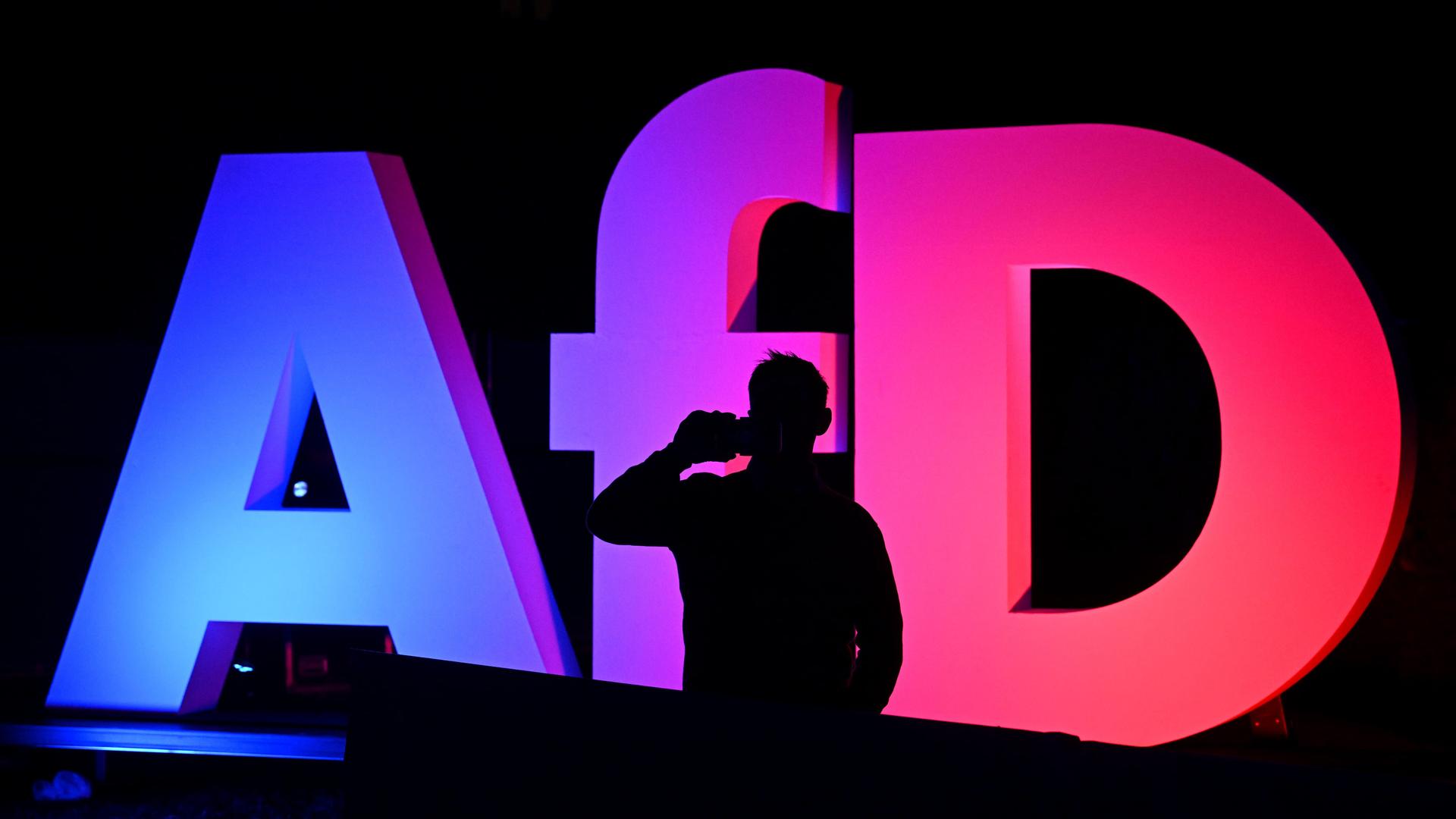 Ein Mann telefoniert bei der Wahlparty der AFD in der AfD Bundesgeschäftsstelle vor dem Logo der Partei. Am Sonntag fand die vorgezogene Wahl zum 21. Deutschen Bundestag statt.