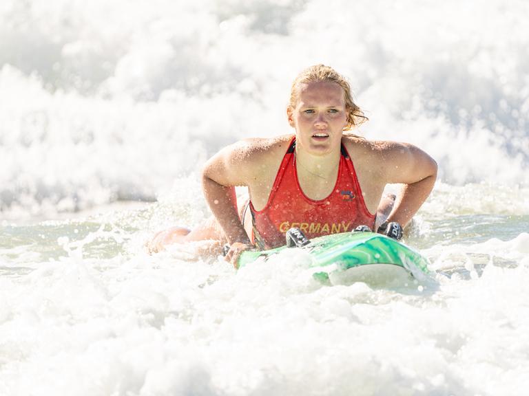 Die Sportlerin Lea Kötter bei der WM der Rettungsschwimmer 2024 in Australien. Lea Kötter liegt auf einem Rettungsbrett im Meer und bewegt sich in den Wellen.