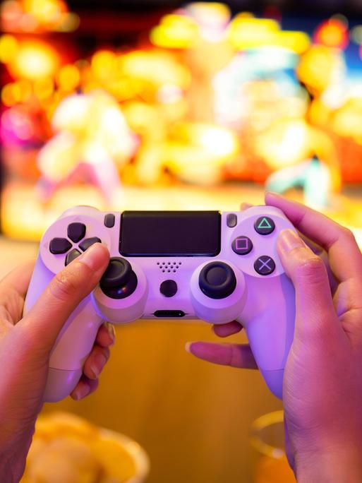 Eine Frau spielt ein Computerspiel mit einer Konsole