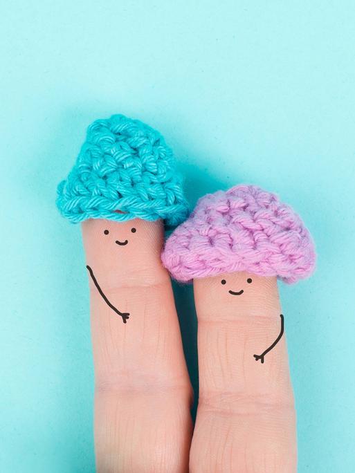 Zwei Finger nebeneinander, auf die lächelnde Gesicht gemalt sind