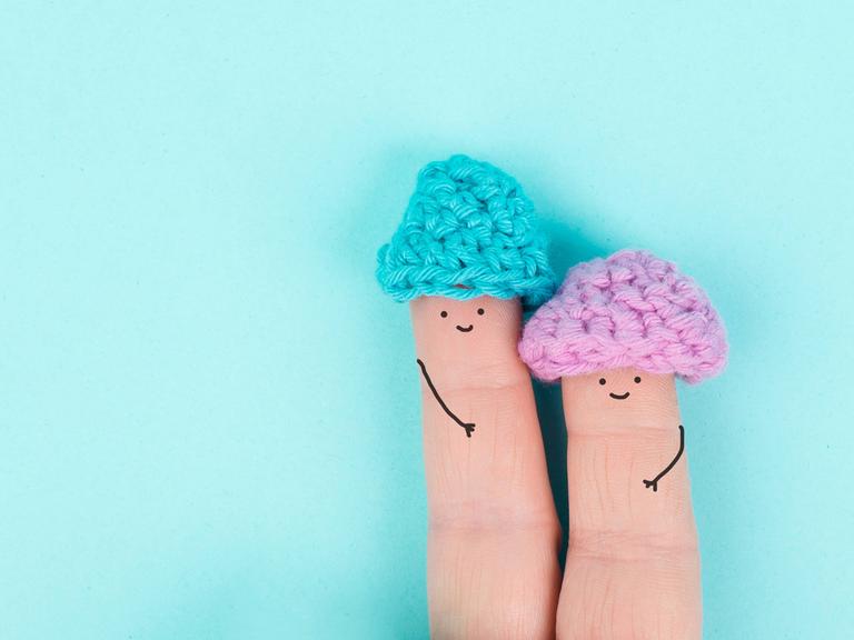 Zwei Finger nebeneinander, auf die lächelnde Gesicht gemalt sind