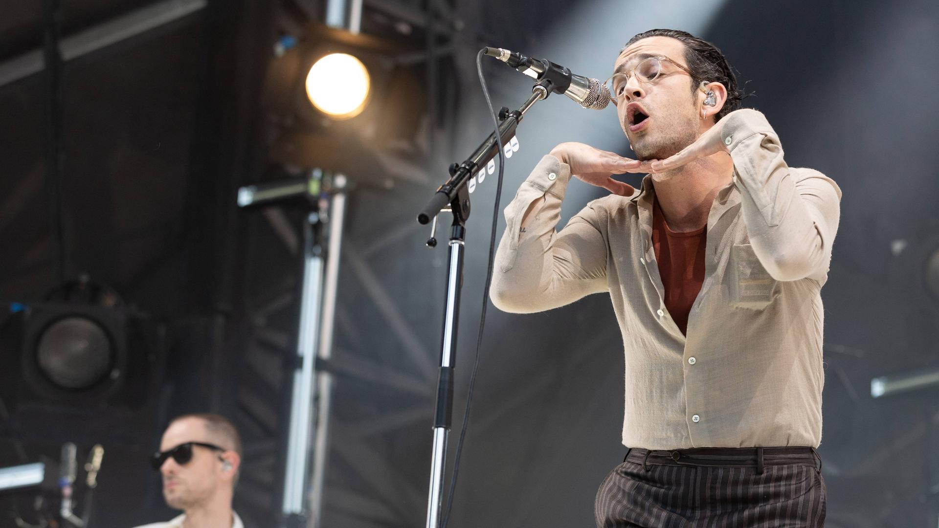 The 1975 mit Sänger Matty Healy bei einem Konzert auf der Bühne. The 1975 mit Sänger Matty Healy bei einem Konzert auf der Bühne.
