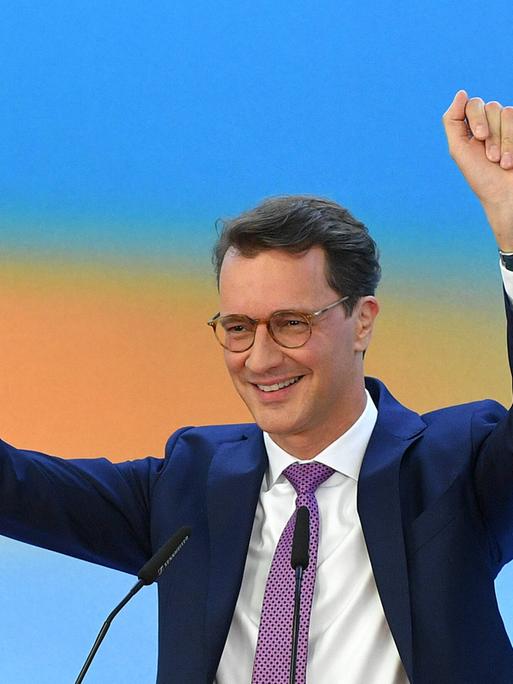 Hendrik Wüst reckt nach der ersten Prognose die Arme in die Luft. 