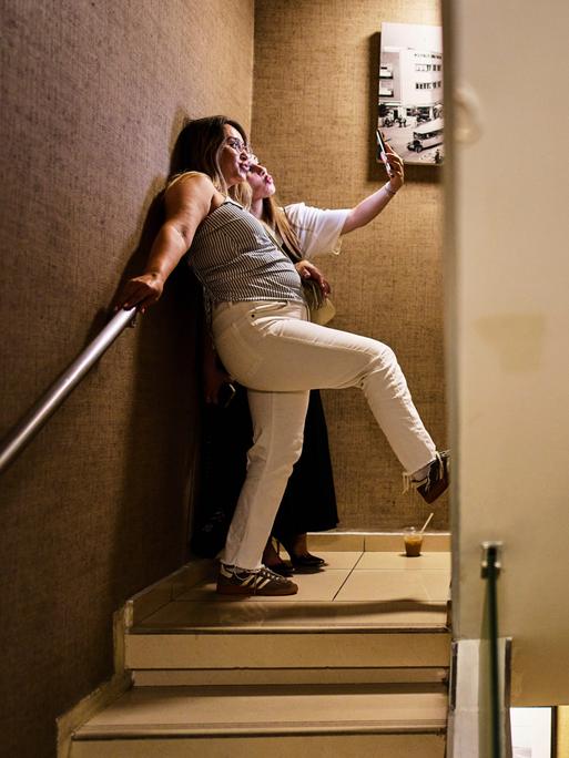 Zwei Frauen stehen in einem Hoteltreppenhaus zum Schutzkeller in Tel Aviv und machen mti einem Handy ein Selfie.