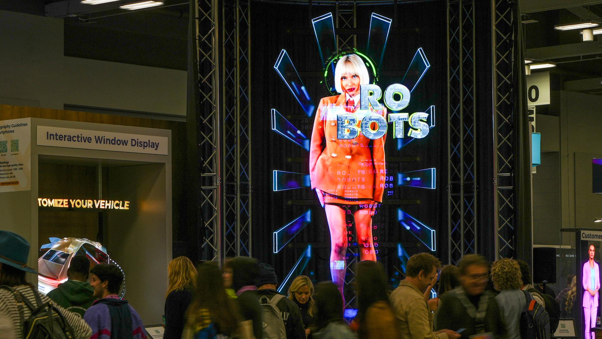 Auf einem Display auf dem South-by-Southwest-Festival in Austin ist die graphische Darstellung einer Frau zu sehen, vor ihr steht das Wort "Robots" geschrieben. 