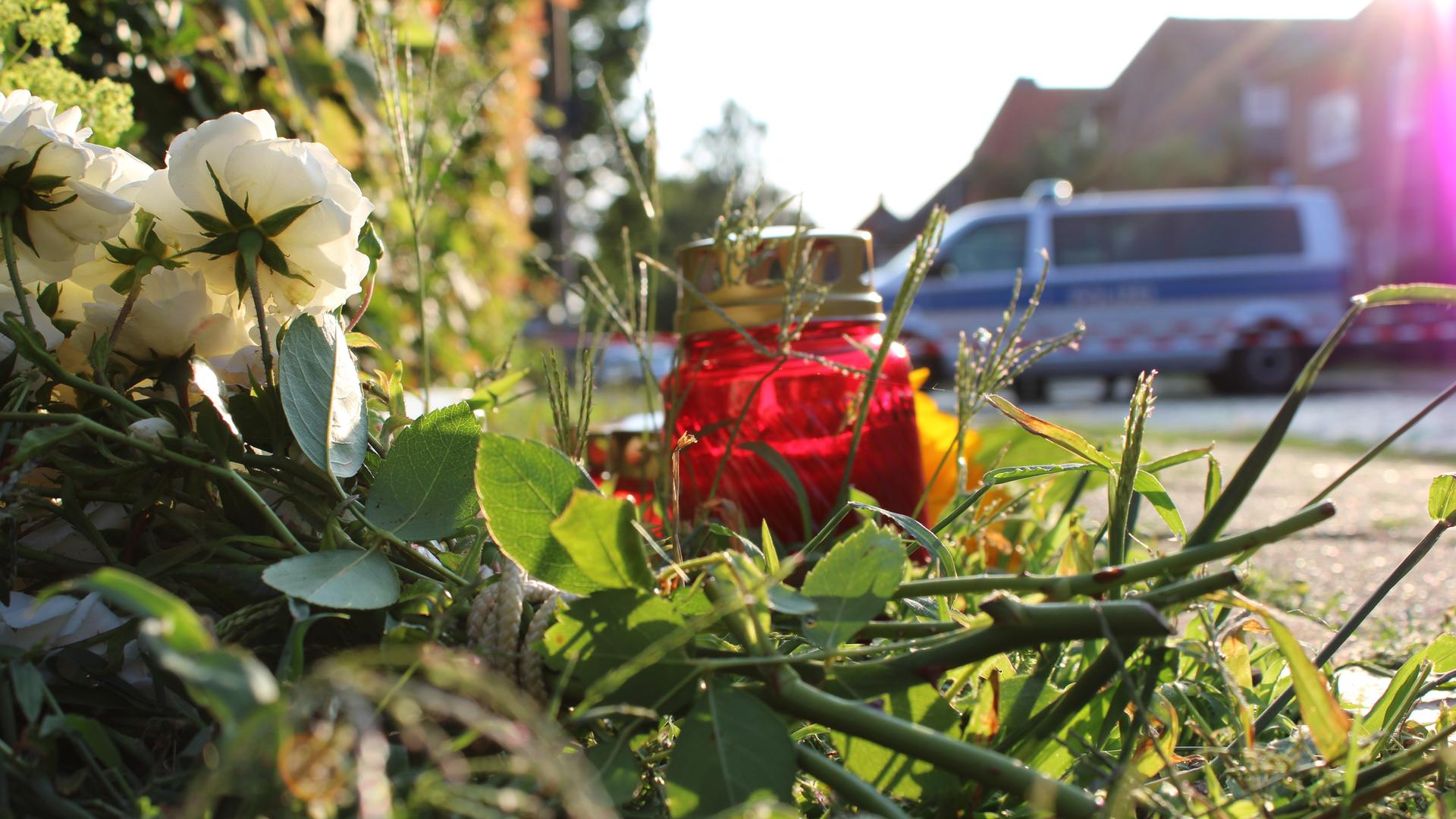 Blumen und Kerzen stehen und liegen am Tatort, einem Gebäude einer Jugendeinrichtung. In der Einrichtung waren am Vortag mehrere Menschen durch Schüsse getötet worden.