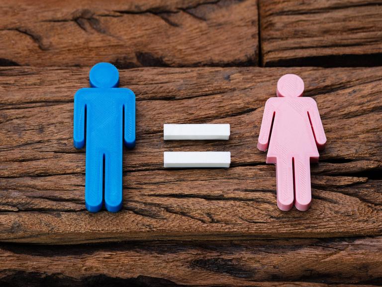 Symbolbild von Gleichberechtigung. Eine männliche Figur wir mit dem Gleichzeichen einer weiblichen Figur gleichgesetzt. 
