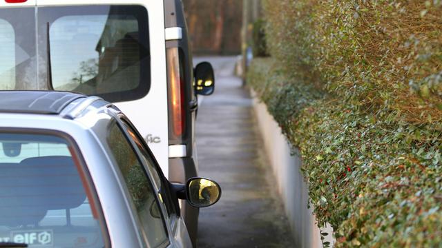 Autos parken auf einem Geh-Weg. 