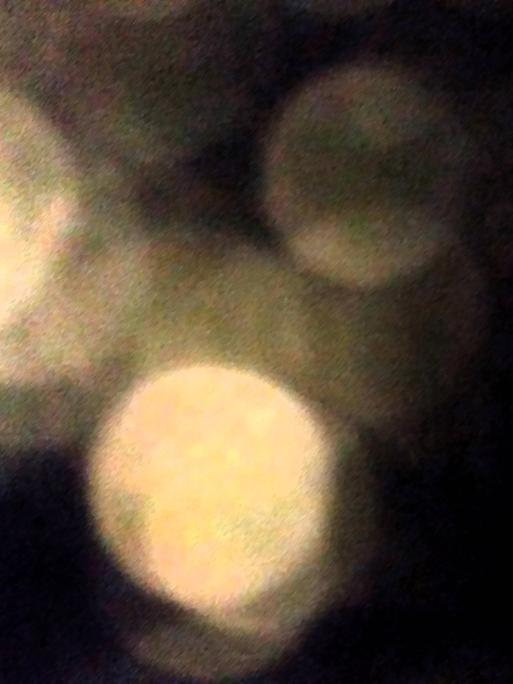 Schwarzer Hintergrund, davor abstrakte Kreise wie Lichtkegel, manche stärker, andere schwächer.